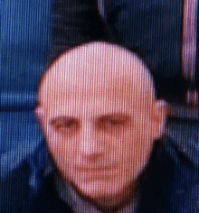 a blurry picture of a man 's face with a bald head