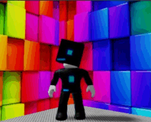 a robot with a box on his head is standing in front of a wall of colorful blocks .