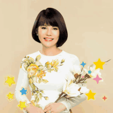 a woman wearing a white dress with flowers on it is smiling