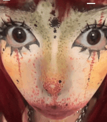 a close up of a woman 's face with a lot of makeup on it