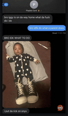 a baby is laying on a pillow with converse shoes on