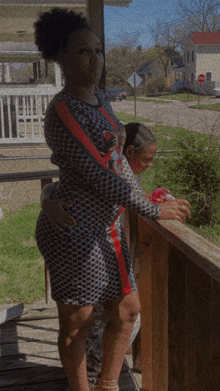 a woman in a gucci dress stands on a balcony