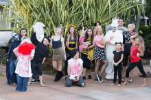 a group of people dressed up in halloween costumes pose for a picture