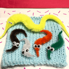 a bunch of worms with googly eyes on a blue sweater