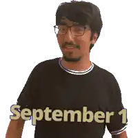 a man wearing glasses and a black shirt with the date september 1 on it
