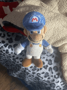 a stuffed mario wearing a blue hat with a red m on it