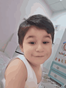 a little boy is smiling in front of a dresser that has the numbers 3 and 4 on it