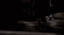 a woman is standing next to a man who is laying on a bed .