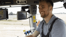 a man sitting in the driver 's seat of a tractor with the words premium sound system on the bottom right