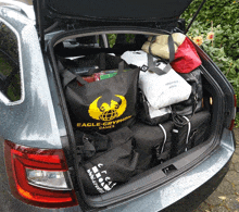 the trunk of a car is filled with bags and a bag that says eagle-cryption games