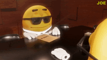 a yellow smiley face with sunglasses is sitting at a table with a piece of paper that says ' joe ' on it