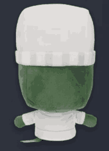 a green stuffed animal with a white hat and a white sweater .