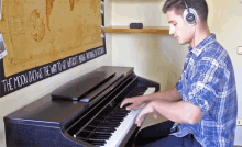 a man playing a piano in front of a sign that says " the moon glows the way to go "