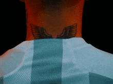 a man has a tattoo on his neck that looks like wings