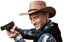 a man wearing a cowboy hat is holding a gun