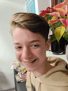 a young man is smiling in front of a potted plant and a sign that says ' private ' on it