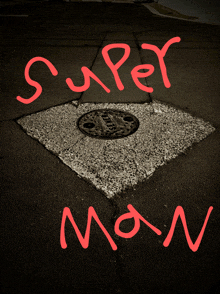 a manhole cover on the sidewalk with the words super man written in red