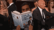 a man in a tuxedo is reading a book titled losing to jeffrey tambor with dignity