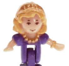 a small toy doll with blonde hair and a purple dress