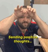 a man with a beard is wearing a shirt that says ' sending positive thoughts ' on it