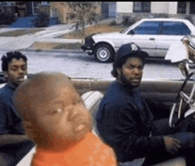 a group of men are sitting in a car with a baby in the back ..