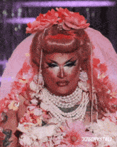 a drag queen is wearing a veil and pearls and has xtecrystali written below her