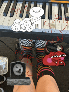 a person wearing a pair of striped socks is sitting under a piano keyboard