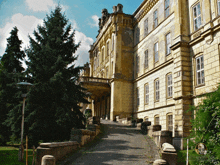 a large building with a balcony and a tree in front