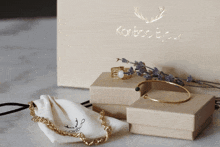 a bracelet and a ring are sitting on a table in front of a box that says konboo bijoux