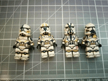 four lego storm trooper figures are lined up on a cutting board