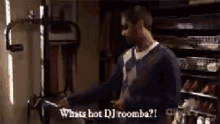 a man is standing in a room with the words what 's hot dj roomba ?