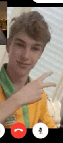 a young man is giving a peace sign while having a video call .