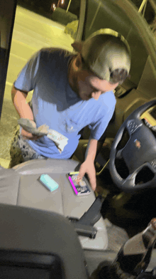 a man in a blue shirt is sitting in the driver 's seat of a chevrolet truck
