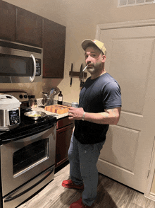 a man smoking a cigarette in a kitchen with a microwave