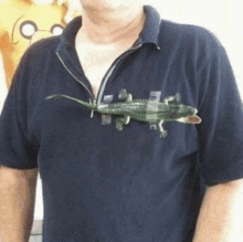 a man in a black shirt has a toy lizard sticking out of his shirt