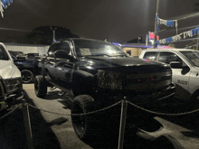 a black truck is parked next to a white ram truck