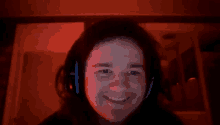 a woman wearing headphones is smiling in a red room