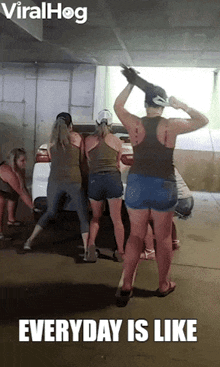 a group of women are dancing in front of a car with the caption " everyday is like "