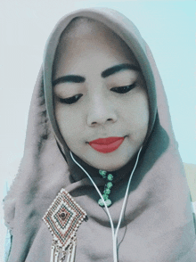 a woman wearing a hijab and a brooch with a diamond on it