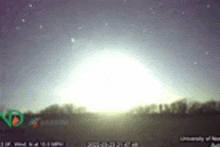 the sun is shining brightly in the night sky above a field