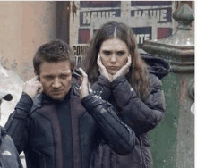 a man and a woman are standing next to each other on a sidewalk .