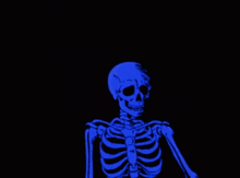 a blue skeleton is glowing in the dark against a black background .