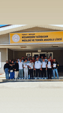 a group of people are posing for a picture in front of a building that says tokat-niksar