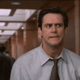 a man in a striped shirt and tie making a funny face .