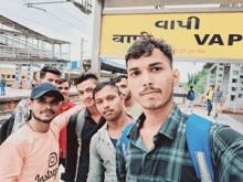 a group of young men are posing for a photo in front of a sign that says vap