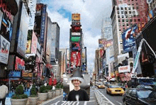 a man in a santa hat is standing in a busy city street .