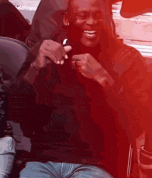 a man in a black shirt is smiling and holding a cell phone