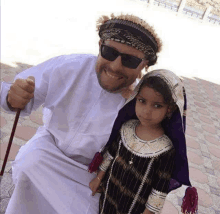 a man and a little girl are posing for a picture .