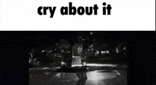 a black and white photo of a man standing in front of a car with the words `` cry about it '' written on the bottom .