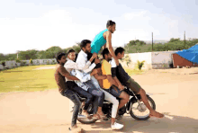 a group of people are riding on a motorcycle and one of them is holding another man on his shoulders